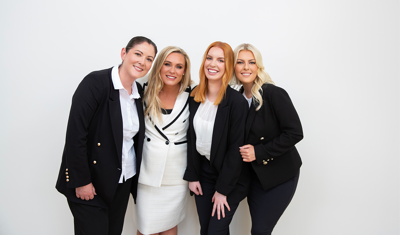Smart Lending team of four women in business attire posing together with smiles.