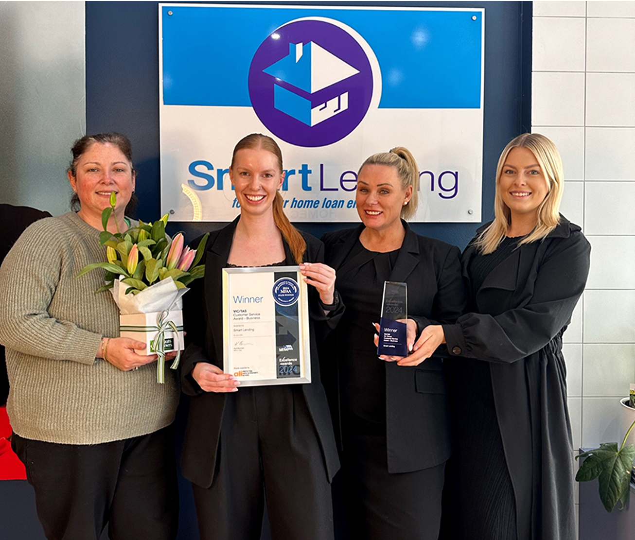 Smart Landing team celebrating their award win with certificates and trophies.